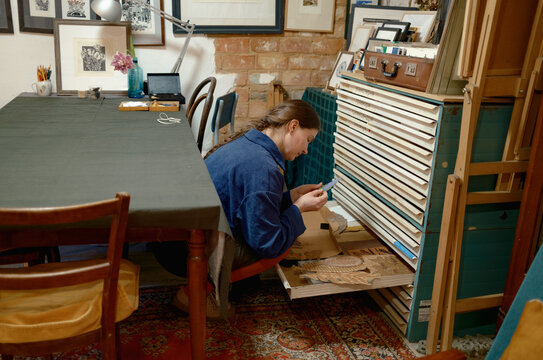 a female artist lays out her works on a table