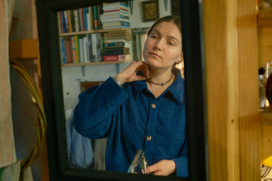 a woman looks at her reflection in the mirror