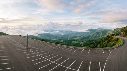 Fototapeta premium Panoramic View of Empty Parking Lot Overlooking Lush Green Mountains and Clouds.