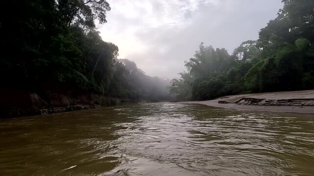 Misty Tropical River Bend in Ecuador with Dense Rainforest, Brown Water, Cloudy Sky and Remote Amazon Boat Travel Wilderness Landscape