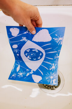 Hand Holding Cyanotype Print Over Sink