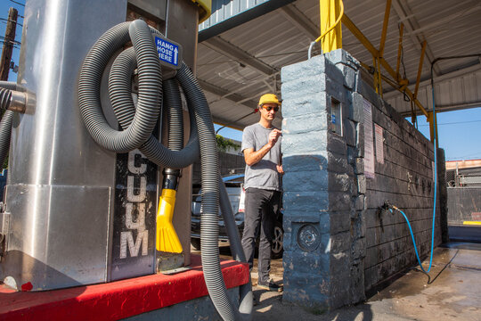 Man Inserting Coins at a Carwash