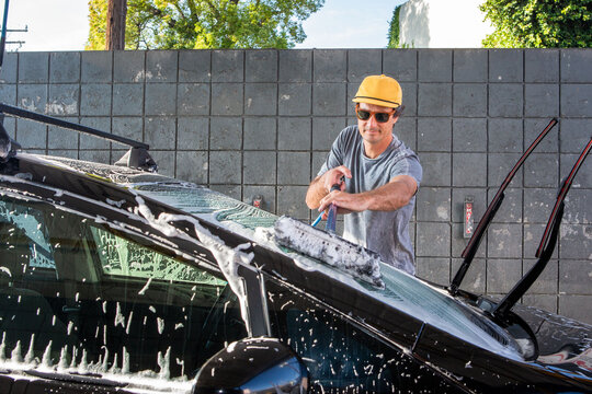 Man Using Soapy Brush at Carwash