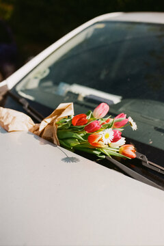 Flowers placed on a car windshield in a parking area