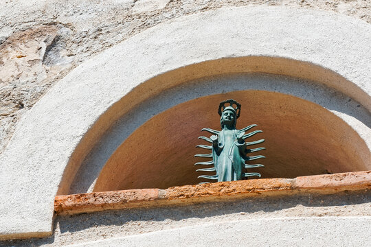 Petite statue vierge orante entour&eacute;e de rayons et portant une haute couronne fleuronn&eacute;e qui orne l&rsquo;entr&eacute;e d&rsquo;un ancien b&acirc;timent militaire &agrave; Toulon en Provence, France.