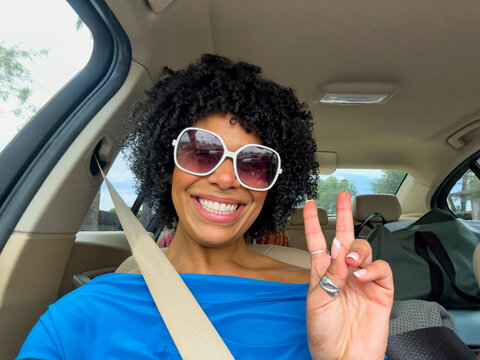Black Girl friend smile car on Road Trip with peace sign 