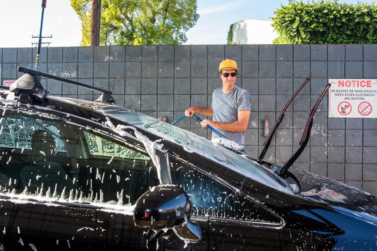 Man Using Soapy Brush at Carwash