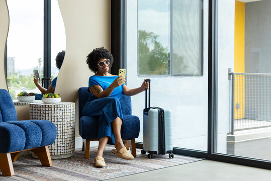 Black woman fashion travel lifestyle with cell phone luggage 