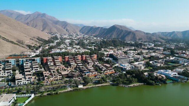 Aerial shot of the exclusive La Planicie gated community in Lima, Peru, showcasing luxury mansions lining the central artificial lagoon in La Molina.