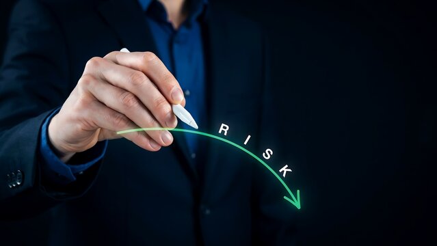 Business professional showing risk reduction concept with downward arrow on dark background