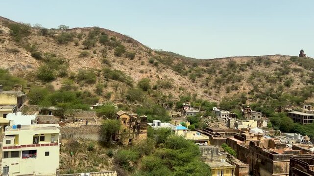 Panoramic view of the Aravalli Hills and traditional village landscape seen from Amer Fort in Jaipur, Rajasthan, India. Scenic countryside, historic surroundings, and natural beauty under a clear sky.