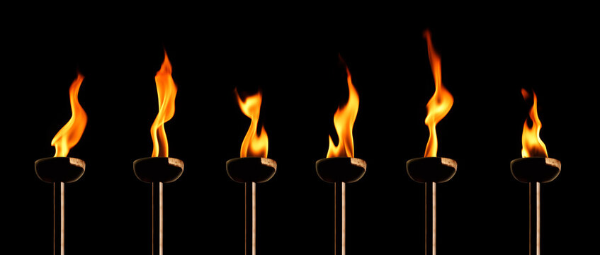 group of burning flaming torches over black background