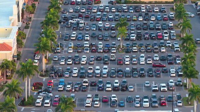 Suburban shopping plaza with parking rows and crowded car spaces. Weekend rush, retail activity and community lifestyle concept.
