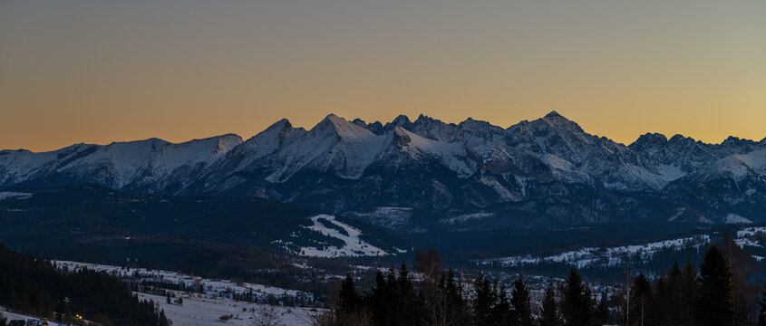 Majestic Tatra mountains landscape covered with snow in winter. Panoramic view of snowy rocky peaks against blue sky