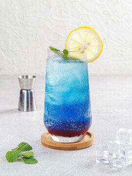 Blue Gradient Lemon Mocktail with Mint Garnish on White Textured Background