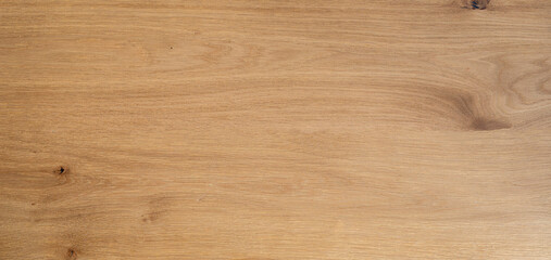 Natural light oak wood texture background with smooth flowing grain pattern. Single wide wooden plank surface close-up, clean minimal backdrop.. © valiantsin
