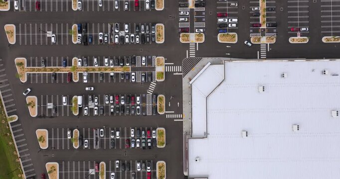 Urban shopping district with packed car parking lots, representing congestion, city life and active business environment.