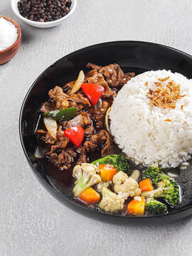 Asian Beef and Vegetable Stir Fry Served with White Rice, Beef Stir Fry with Mixed Vegetables and Steamed Rice on Black Plate