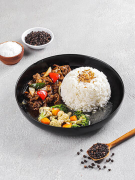 Asian Beef and Vegetable Stir Fry Served with White Rice, Beef Stir Fry with Mixed Vegetables and Steamed Rice on Black Plate