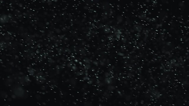 Abstract dark textured background with small light specks and particles.