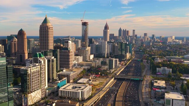 Aerial view of downtown Atlanta city landscape with skyscraper buildings and flowing highway traffic, highlighting urban growth, transportation infrastructure and modern American metropolis