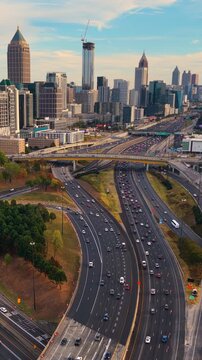 Aerial view of downtown Atlanta city landscape with skyscraper buildings and flowing highway traffic, highlighting urban growth, transportation infrastructure and modern American metropolis.