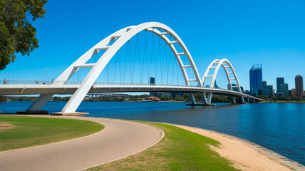 Fototapeta premium A scenic view of a bridge spanning a river with a cityscape in the background and a pathway leading to it.