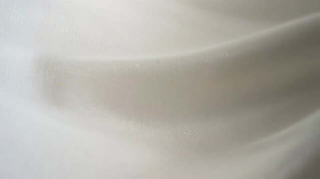 Soft white fabric flowing elegantly in slow motion closeup sequence