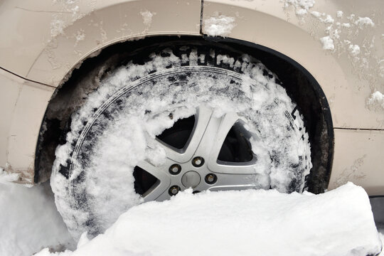 Car tires in deep snow. A challenging road and transportation concept.