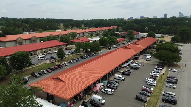 Aerial view of the North Carolina State Farmer's Market in Raleigh, with the city skyline in the distance