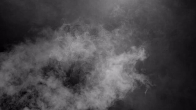 Dense white smoke billowing on a dark black background.