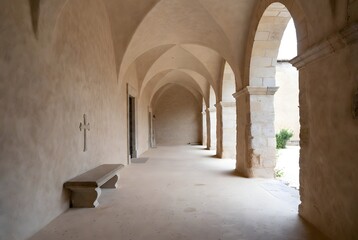 Fototapeta premium a serene healing concept represented by a simple stone bench beneath a small cross carved into a cloister wall