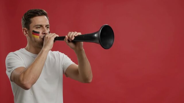 Man with German flag face paint blows vuvuzela horn in support of World Cup team