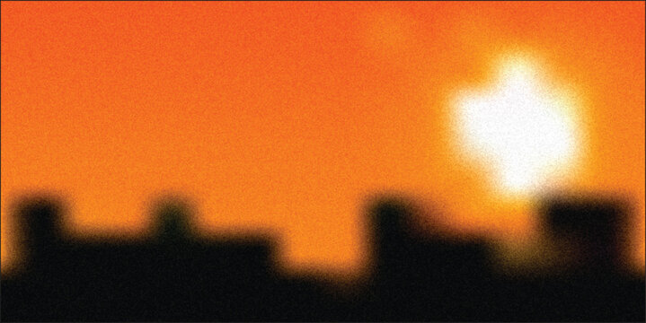 Sunset over city skyline with orange sky, clouds and glowing horizon in evening light