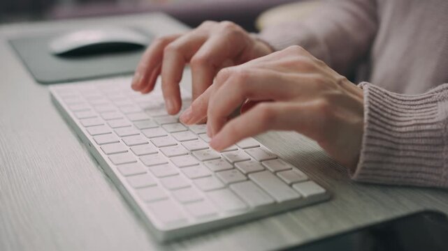 Close Up of Hands Typing on Computer Keyboard at Desk
