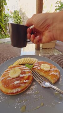 Hand Reaching for Coffee During Tropical Poolside Breakfast With Fresh Banana Pancakes, Relaxed Vacation Morning And Resort Lifestyle