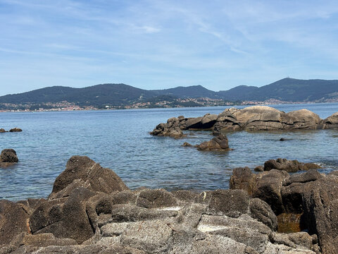 Rocky shoreline and calm waters at Samil Beach in Vigo Galicia Spain