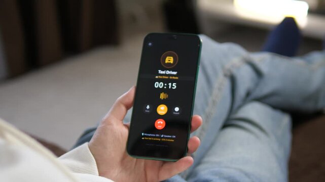 Hands holding a phone during an active taxi call. The dark interface highlights the driver status and call duration. Great for showcasing commuting, digital transportation, and lifestyle technology.