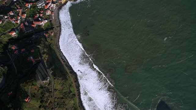 Aerial Porto da Cruz coastline with Alagoa beach and Penha da Aguia rock formation on Madeira island