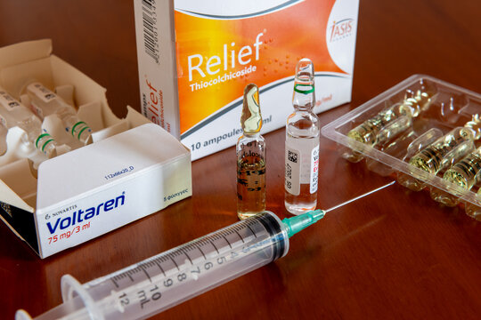 Lefkada, Greece- May 30. 2026. An injection syringe and the ampoules solutions of the back pain treatment medicines Voltaren and Relief thiocolchicoside.