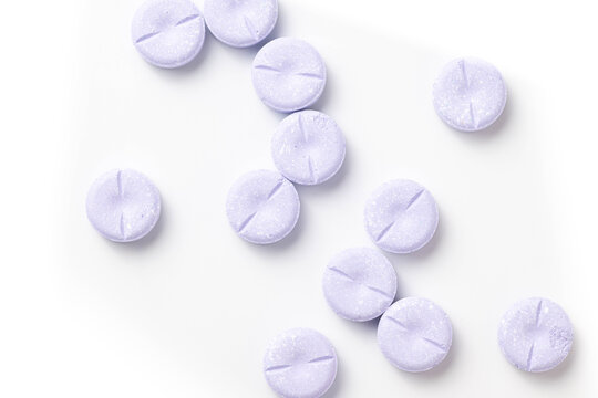 Large, round purple chewable tablets on a white background.