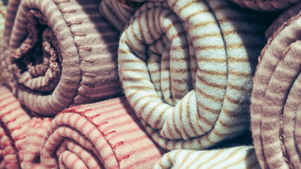 close up of rolled striped fleece blankets with stitched edges © irenka