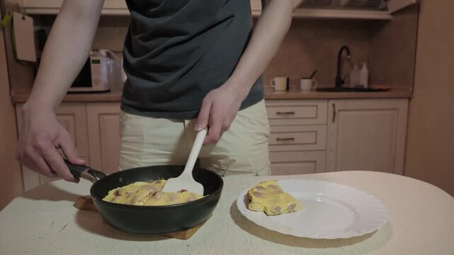 Teen expertly places fluffy eggs. Individual enjoys quick morning meal by placing golden omelette in kitchen
