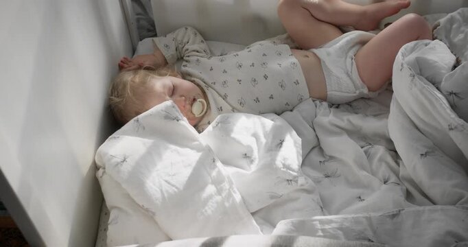 Toddler girl sleeping in crib during daytime nap. Healthy sleep routine and daily rest at home
