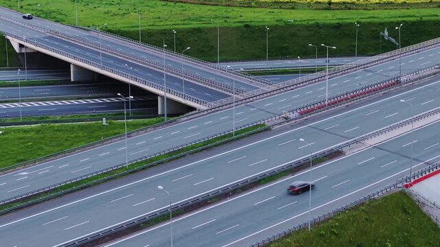 Aerial drone pull-back shot of the massive A1 and A4 highway interchange with empty multi-level overpasses and roads. Abstract geometric views.