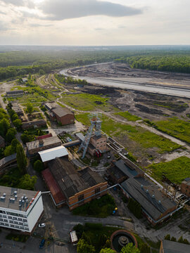 Vertical aerial drone photograph of the historical Makoszowy coal mine complex in Poland. Historic industrial brick buildings and steel headframe.
