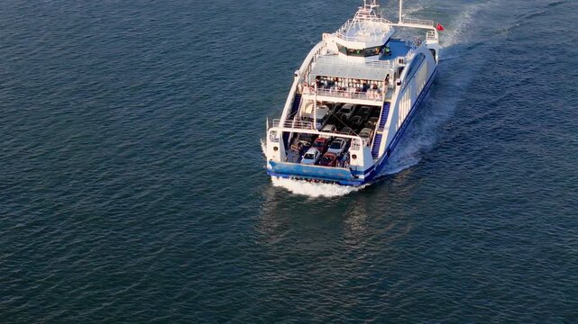 Car ferry carrying vehicles and passengers across open water. Marine transport service for road traffic between coastal districts