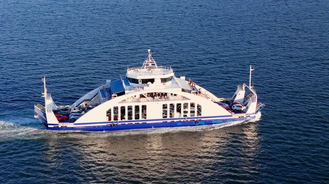 Passenger car ferry in open water during regular city transport route. Marine connection for commuters and local travel