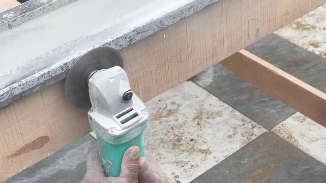 High Angle View of Stone Mason Polishing and Smoothing the Edge of Granite Slab Using Handheld Angle Grinder