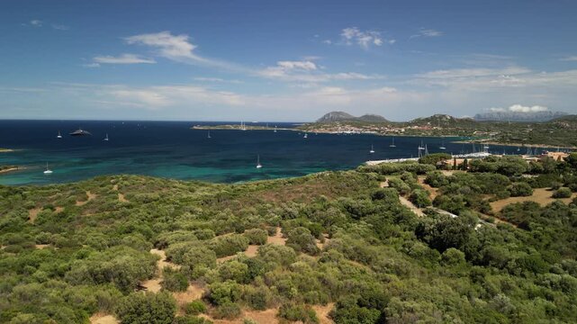 Costa Smeralda - Sardynia - Włochy - Film nagrany dronem. Morze, g&oacute;ry, fale,   ,śr&oacute;dziemomorski klimat, ł&oacute;dki i plaża i piękne widoki na szmaragdowe wybrzeże z powietrza